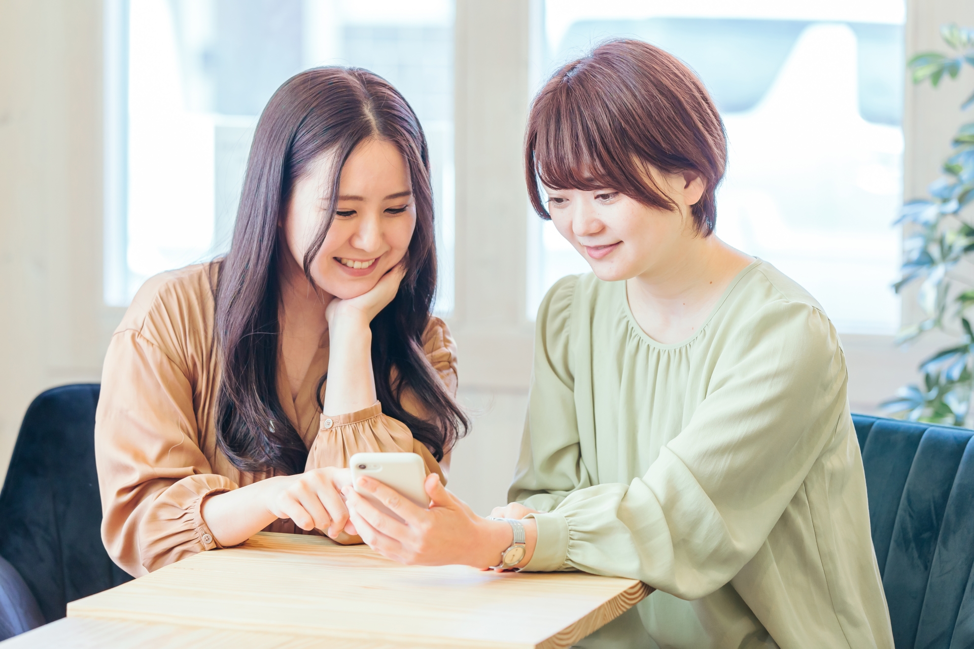 スマートフォンで店選びをする女性たち