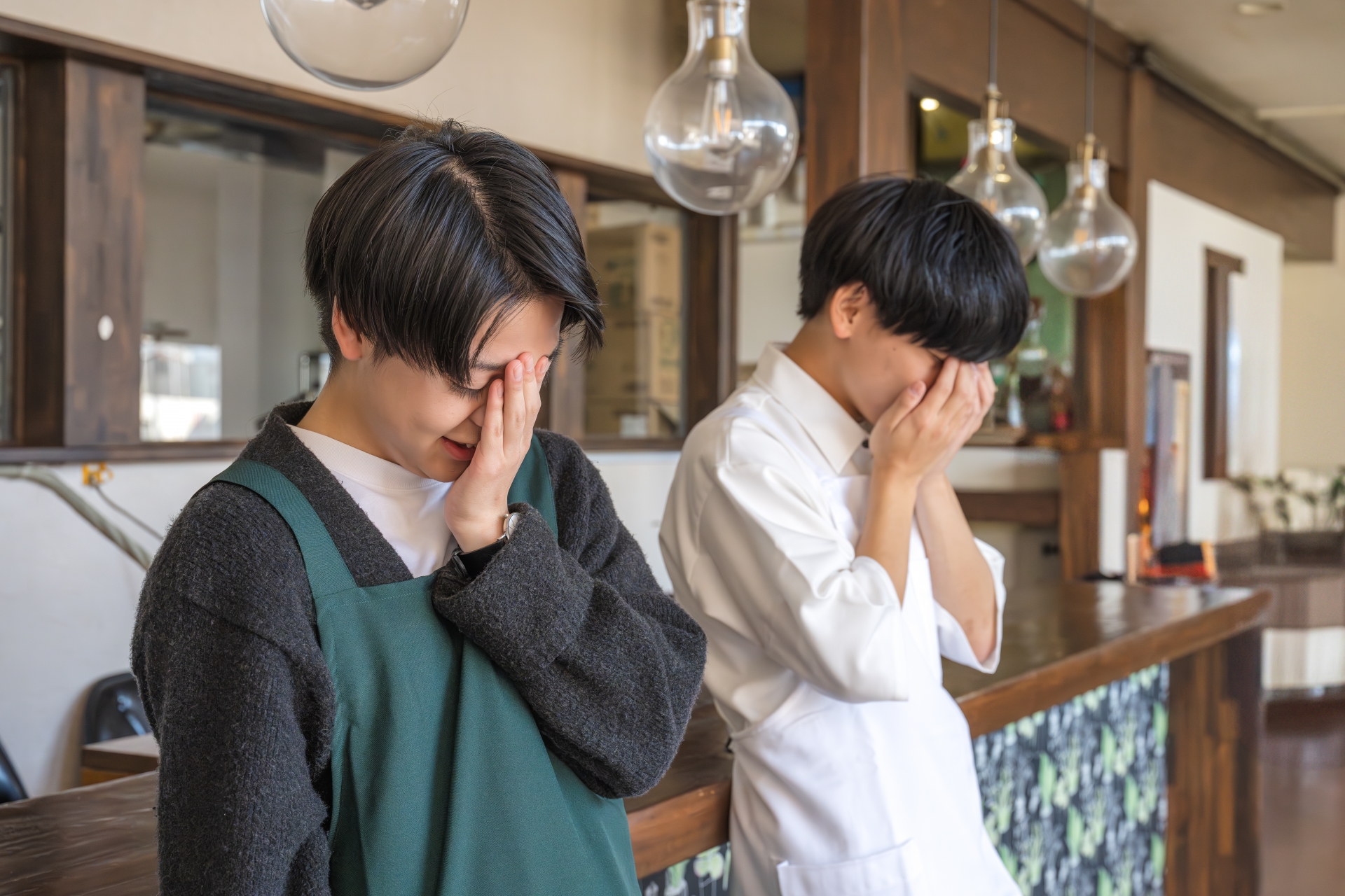 悩む飲食店の男性スタッフ